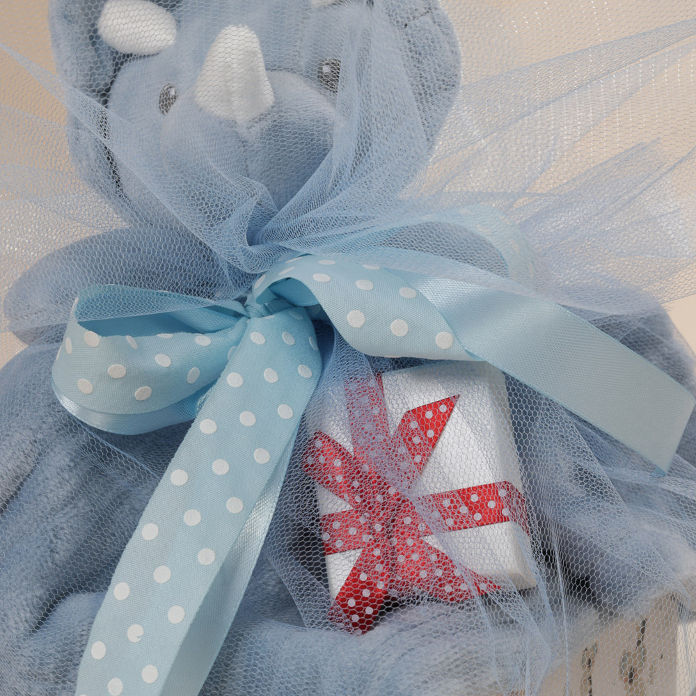 Κοντινή λήψη δώρου για νεογέννητο αγόρι με πανάκι παρηγοριάς και φυλαχρό