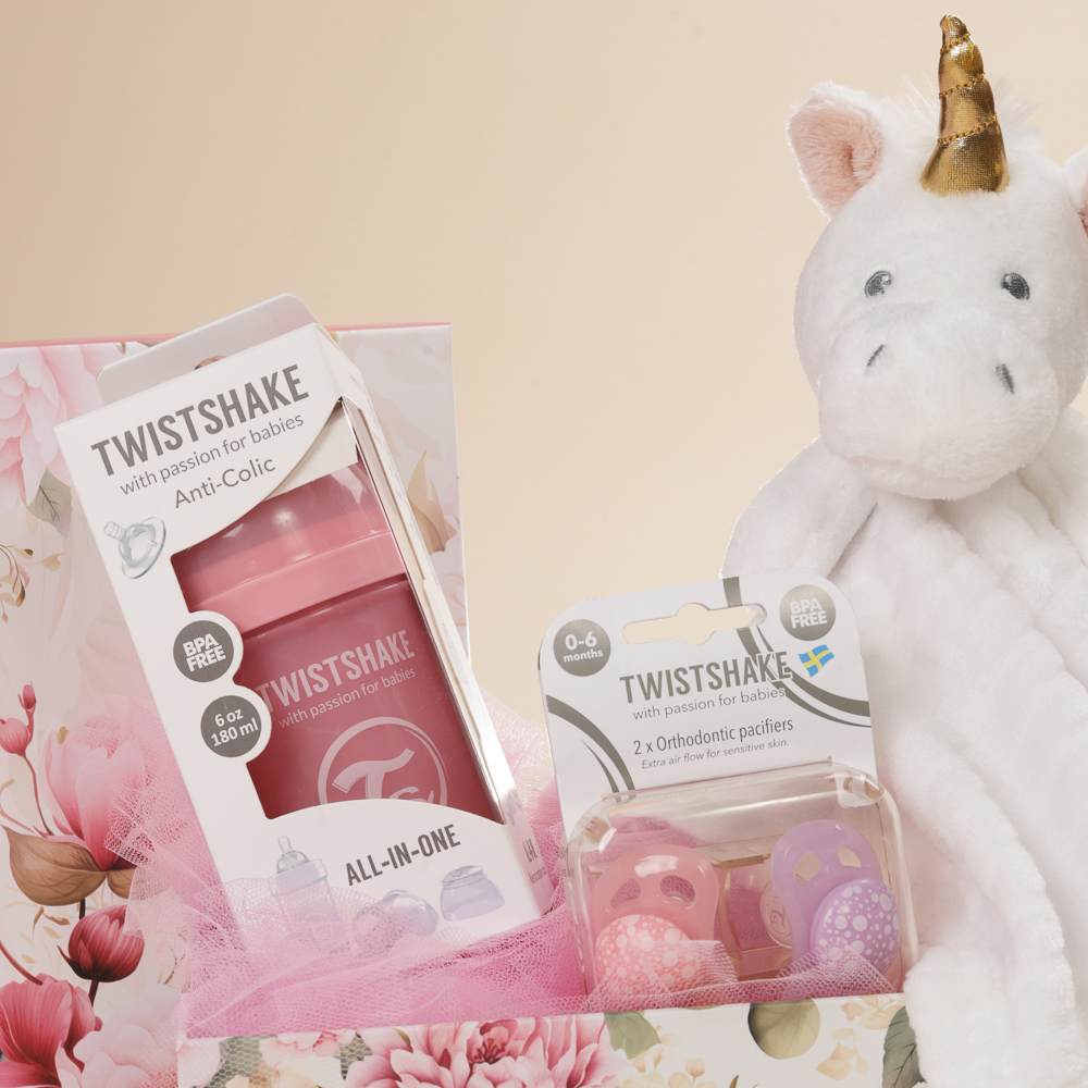 Κοντινή λήψη σετ δώρου γέννησης κορίτσι με μπιμπερό και πιπίλες Twistshake 0-6 μηνών, πανάκι παρηγοριάς μονόκερος και οικολογικό κουτί Babyline.