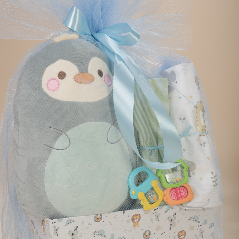 Κοντινή λήψη του σετ δώρου για αγόρι με λούτρινο ζωάκι αγκαλιάς, βαμβακερά σεντόνια λίκνου και κουδουνίστρες σε οικολογικό κουτί Babyline.